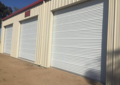 A spacious garage featuring white roller doors